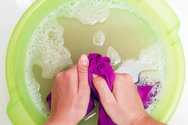 Zdjęcie na górze dziewczyna ręce fioletowe pranie w dorzeczu zielony z pianki wody — Zdjęcie stockowe