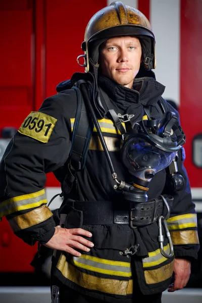 Photo of fireman wearing helmet with gas mask on background of fire engine — Stock Photo, Image