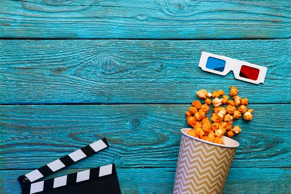 Paper cup with popcorn over blue old wooden table. — Stock Photo, Image