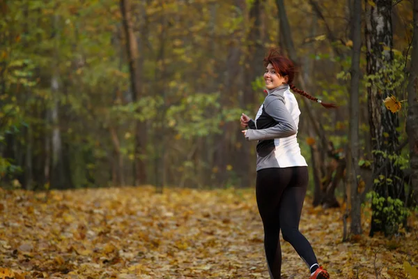 Образ счастливой девушки в спортивной одежде на пробежке осенью — стоковое фото