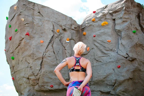 Photo from back of sportswoman climber with bag of soap against rock boulder — Stock Photo, Image