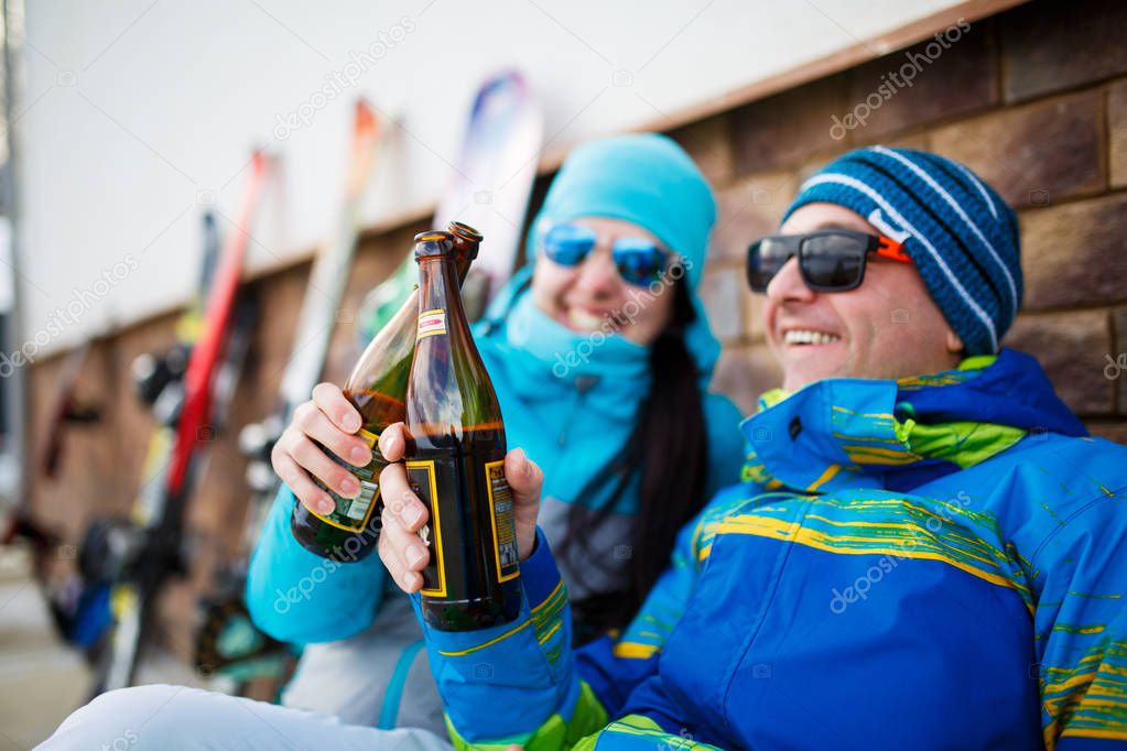 Photo of cheerful man and woman in sunglasses with beer on winter day