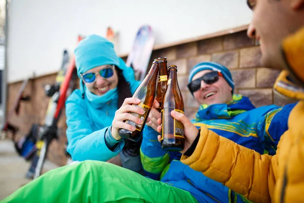 Foto de homens e mulheres sorridentes em óculos de sol com cerveja no dia de inverno — Fotografia de Stock