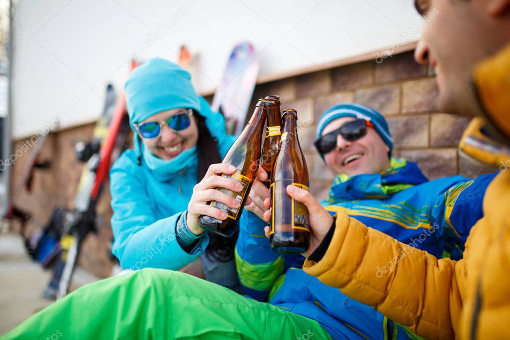 Photo of smiling men and women in sunglasses with beer on winter day