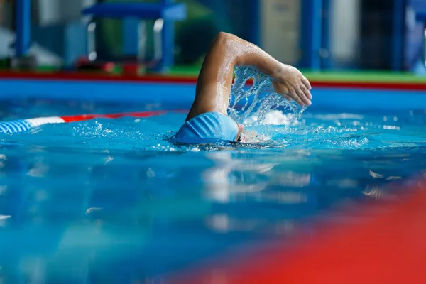 Foto van atletische man in blauwe dop zwemmen in zwembad — Stockfoto