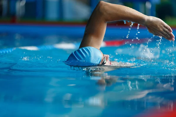 Изображение спортсмена в синей кепке, плавающего в бассейне — стоковое фото