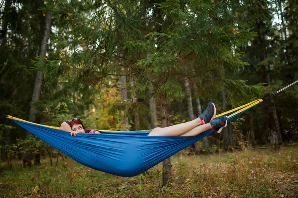 Imagen de una joven tumbada en una hamaca en el bosque — Foto de Stock