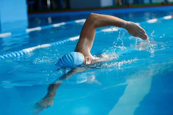 Afbeelding van sport man in blauwe dop zwemmen in zwembad — Stockfoto