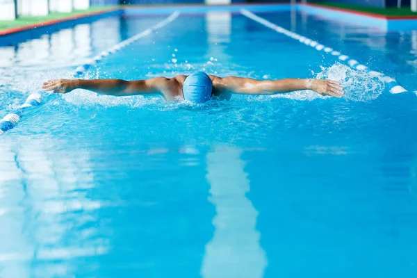 Afbeelding van sportieve man weg in zwembad zwemmen — Stockfoto