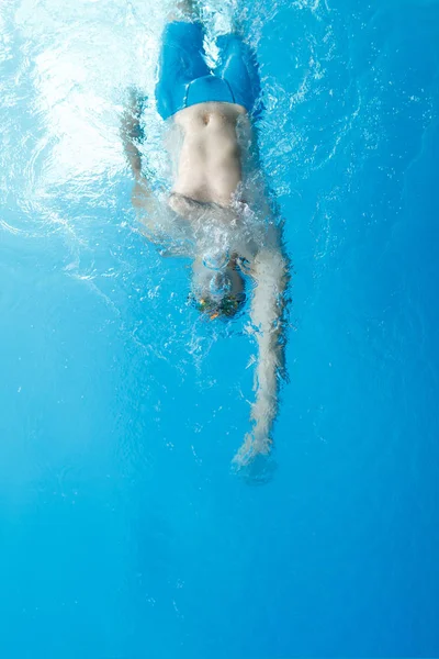 Foto in cima al giovane atleta che nuota sul retro in piscina — Foto Stock