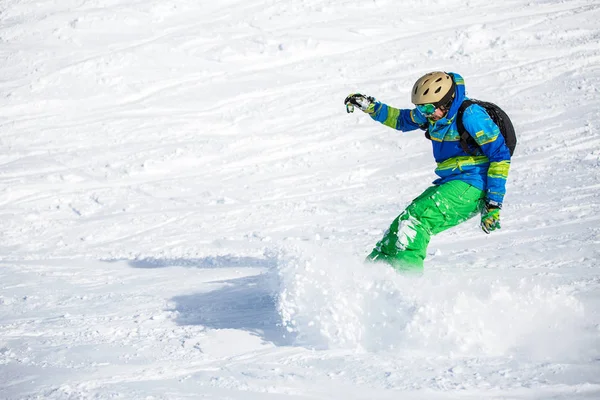 Imagen del deportista feliz haciendo snowboard en la ladera nevada —  Fotos de Stock