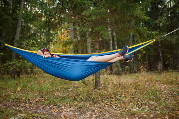 Foto av ung brunett ligga i hängmatta i skogen under dagen — Stockfoto