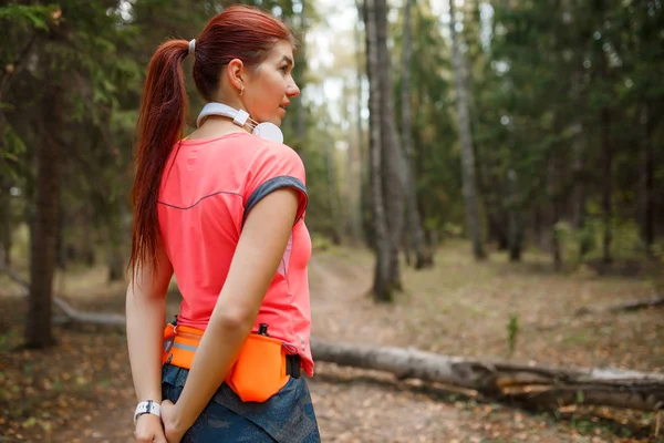 Изображение со спины молодой спортсменки, стоящей в лесу — стоковое фото