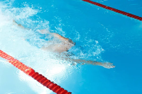 Photo of athlete man swimming under water in swimming pool
