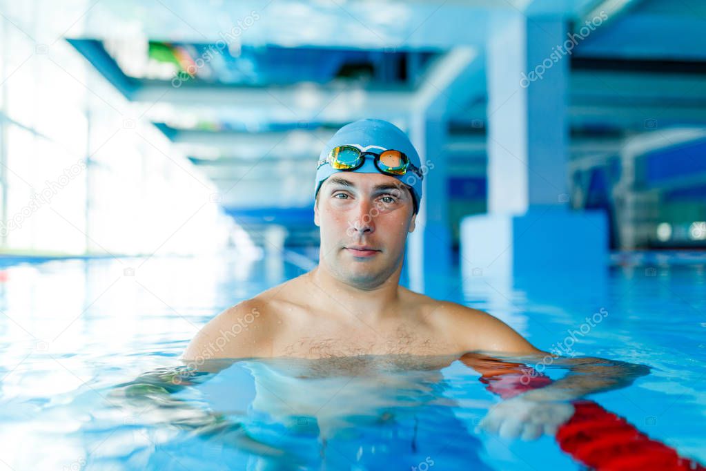 Photo of sports swimmer standing in water at pool