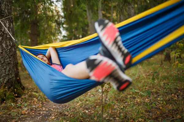 森の中でハンモックに横たわっている若いブルネットのイメージ — ストック写真