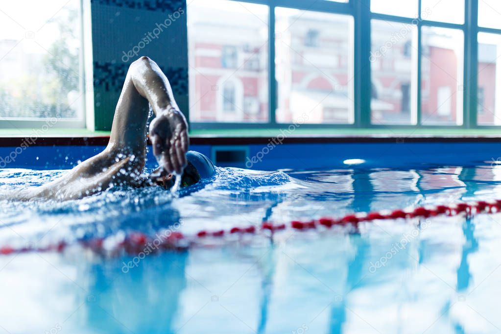 Photo of athlete man swimming in pool indoors