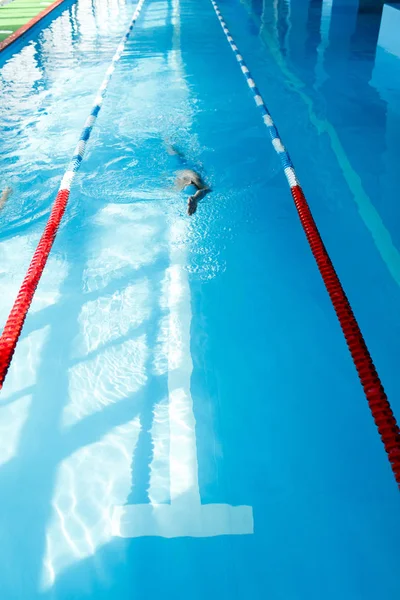 Foto de un joven atleta con gorra azul nadando en la piscina — Foto de Stock