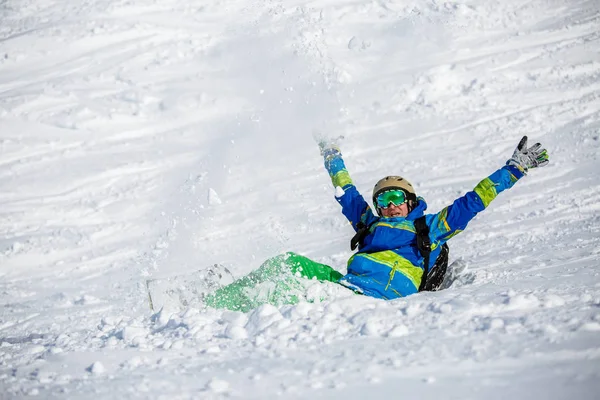 Image d'un sportif avec snowboard couché sur une pente enneigée — Photo