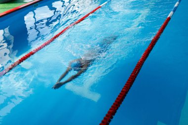 Sporcu mavi şapkalı egzersiz sırasında yüzme havuzu yolu üzerinde görüntü