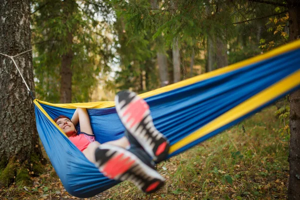 Зображення щасливої брюнетки, що лежить в гамаку в лісі — стокове фото