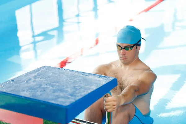 Afbeelding van atleet zwemmer in blauwe dop aan zijkant in zwembad — Stockfoto