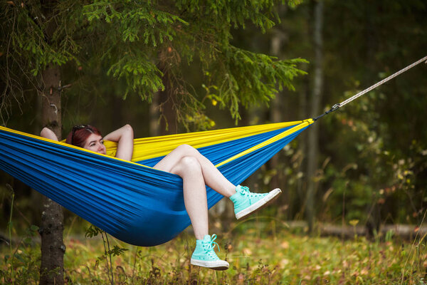 Image of young woman resting in hammock in forest
