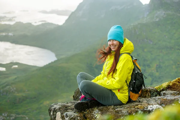 Imagem de menina turística feliz com mochila sentada no topo da montanha no fundo da paisagem pitoresca — Fotografia de Stock