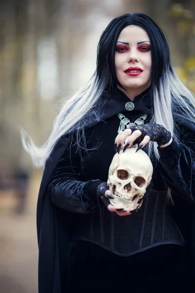 Imagem de mulher bruxa com crânio nas mãos — Fotografia de Stock