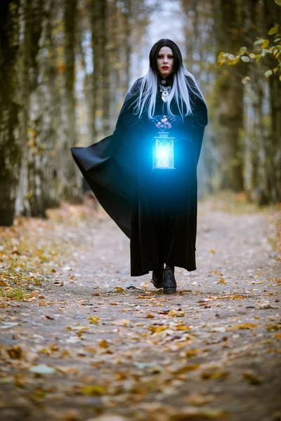 Photo de femme sorcière avec lanterne bleue brûlante dans les mains — Photo