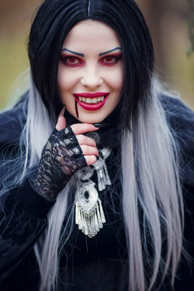 Foto van lachende vampier vrouw met stroom van bloed in de buurt van mond — Stockfoto