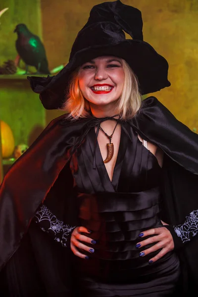 Imagen de bruja sonriente en sombrero negro, vestido —  Fotos de Stock