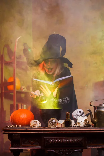 Imagem de bruxa com abóbora e livro de feitiços à mesa — Fotografia de Stock