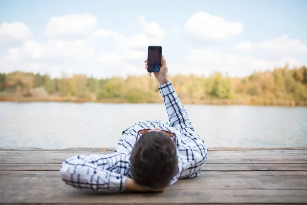 Bild eines jungen Mannes mit Smartphone in der Hand — Stockfoto