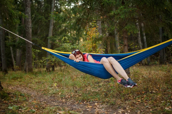 Foto de jovem deitada em rede na floresta — Fotografia de Stock