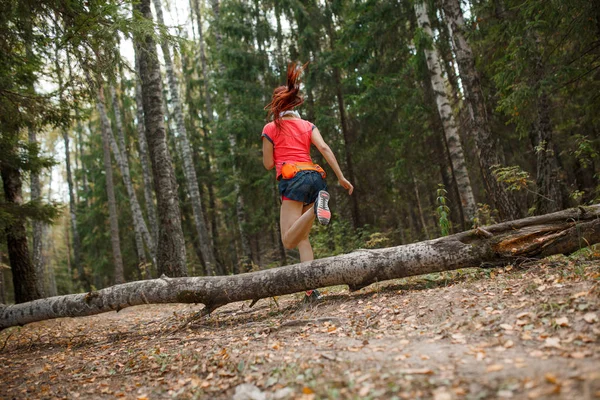 Foto de volta da menina de esportes jovens que correm através da floresta — Fotografia de Stock