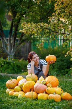 Kabak hasat yeşil çim üzerinde arasında gri önlük bahçıvan esmer gülümseyen bir görüntü
