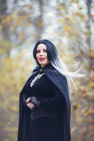 Portret van vampier vrouw in zwarte mantel met amulet — Stockfoto