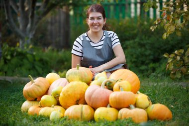 Kabak hasat yeşil çim üzerinde arasında gri önlük bahçıvan kadın fotoğrafı