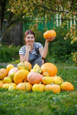 Kabak kabak yeşil çim üzerinde bir ürün arasında elinde bahçıvanla kadın fotoğrafı
