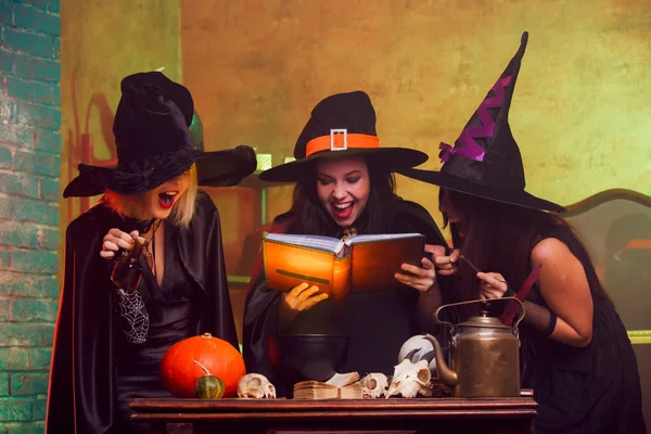 Imagem de três bruxas com livro de previsões nas mãos — Fotografia de Stock