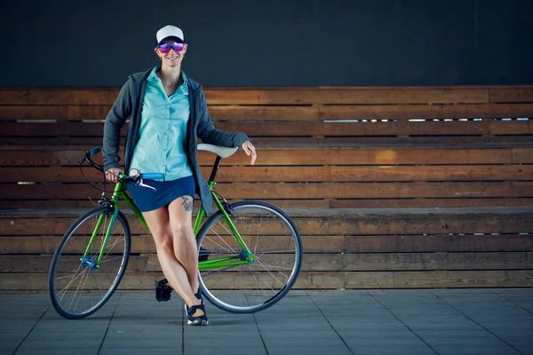 Foto de mujer en gafas de sol de pie con bicicleta —  Fotos de Stock