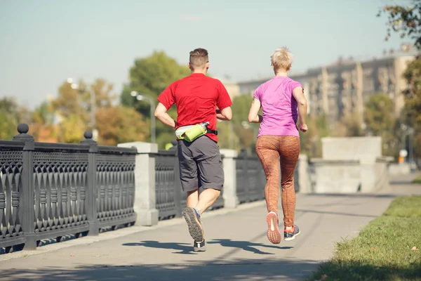 Foto uit achterkant van atletische paar loopt langs de promenade — Stockfoto