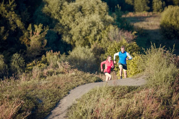 Foto de chica deportiva y hombre trotando entre los árboles — Foto de Stock