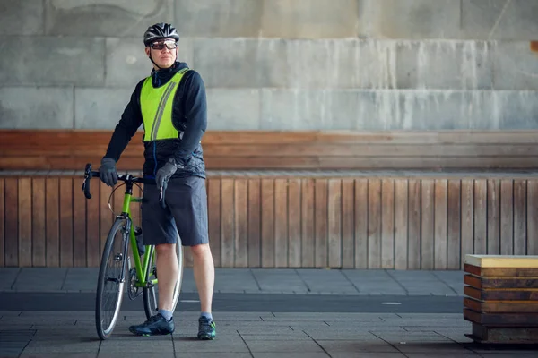 Полноразмерное изображение человека в защитном шлеме, стоящего с велосипедом — стоковое фото
