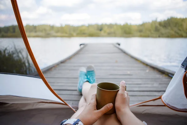 Foto av kvinna med järn Mugg i händer sitter på träbro vid floden — Stockfoto