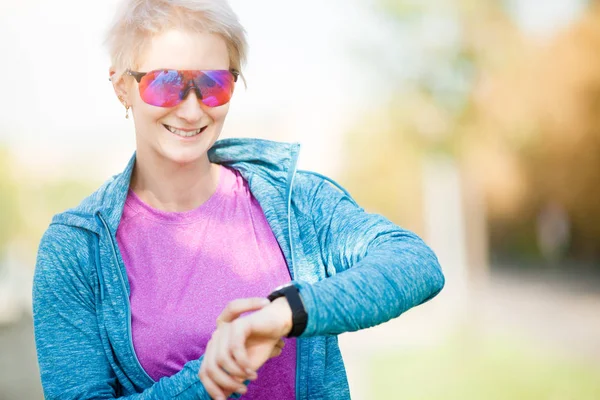 Foto de mulher do esporte olhando para assistir — Fotografia de Stock