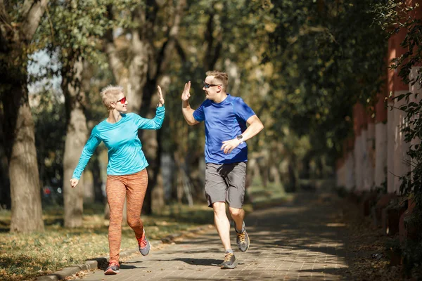 Photo of sporting man and woman doing handshake on morning jog — Stock Photo, Image