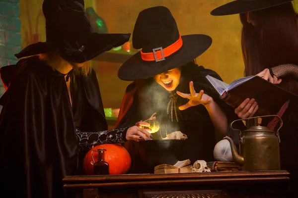 Foto de tres brujas en sombreros cocinando veneno en caldero — Foto de Stock