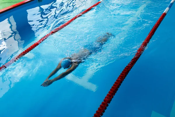 Foto de deportista en gorra azul nadando en el camino en la piscina — Foto de Stock